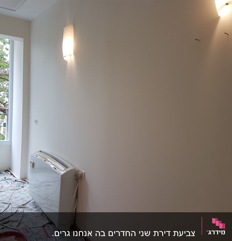 פחיות צבע ומברשת על רצפה מכוסה בניילון